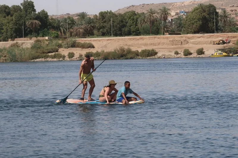 Three paddlers sharing one board on the Nile